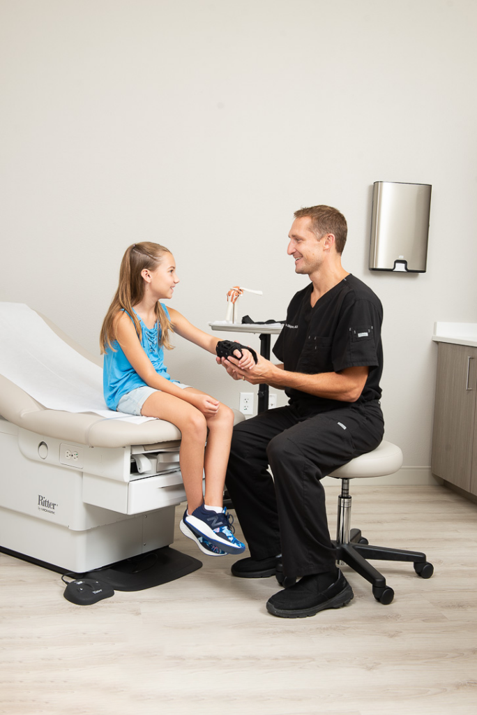 Doctor with young patient considering state of the art physical therapy options